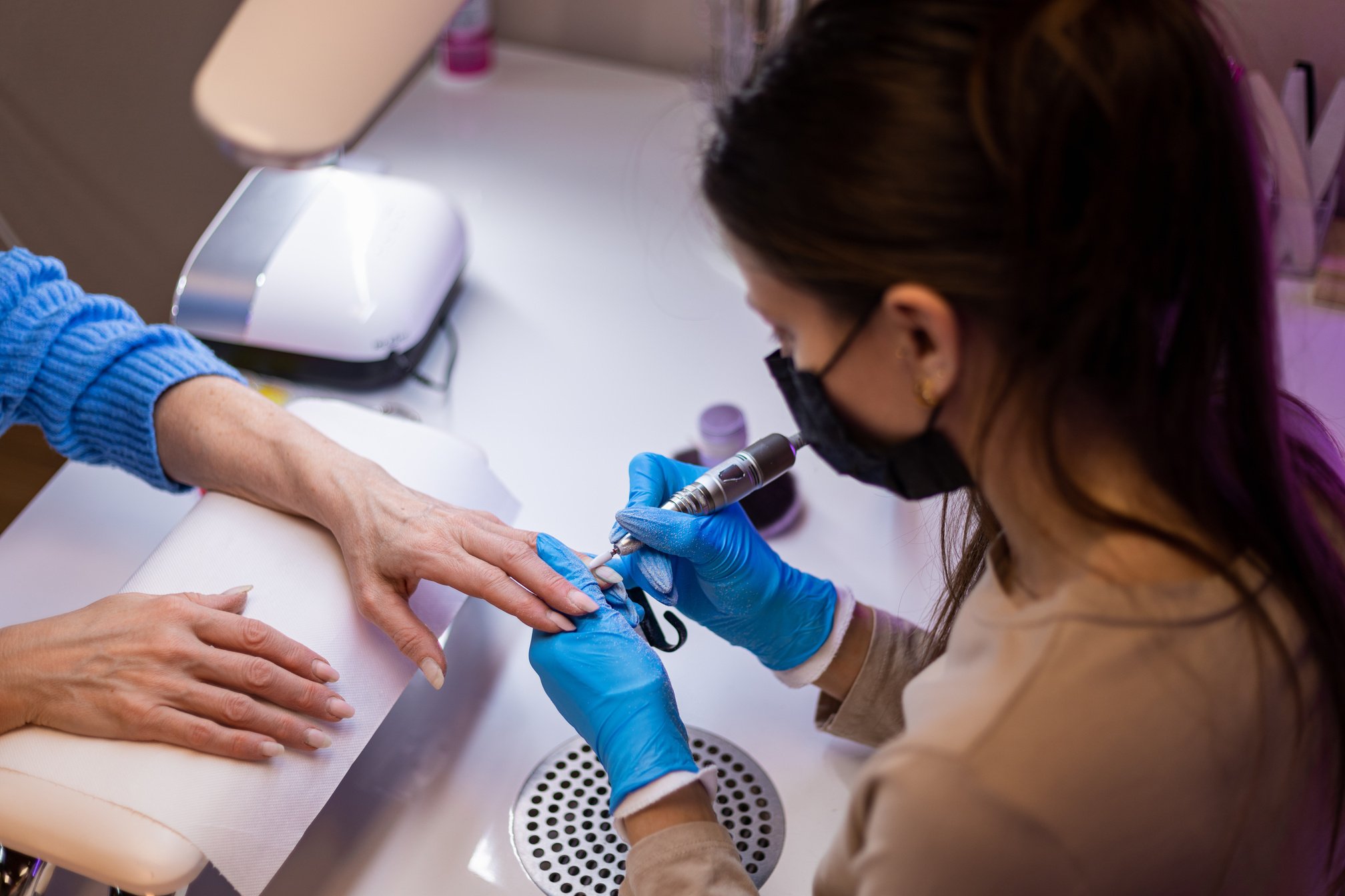 Nail technician doing manicure at her home nail salon