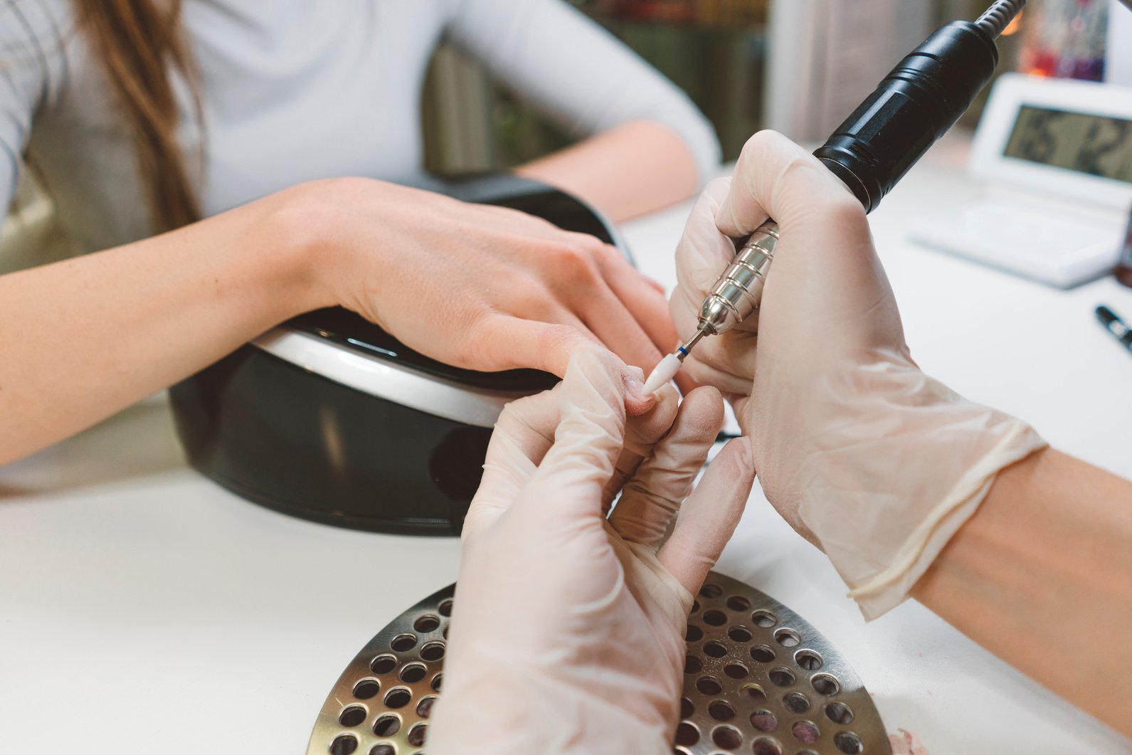 Beautician removing gel with gel polish removal machine